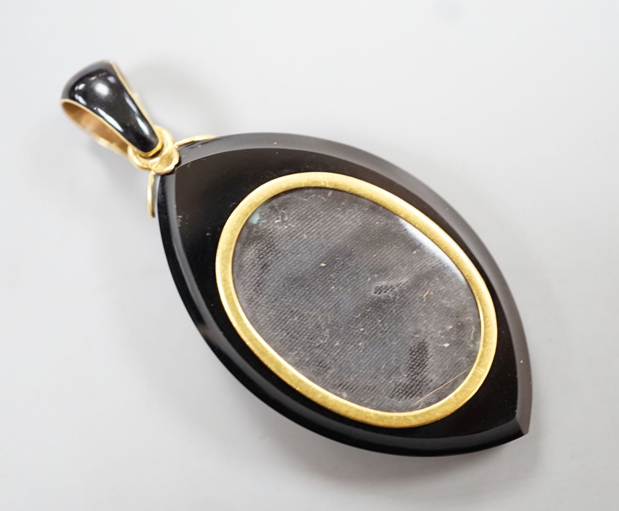 A Victorian yellow metal, black enamel, black onyx and seed pearl set mourning pendant, 57mm (one pearl set motif loose)